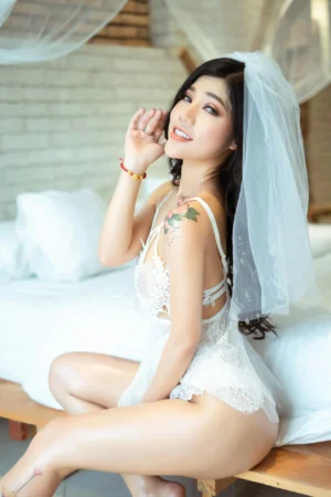 femme brune en lingerie blanche de mariage et voile assise