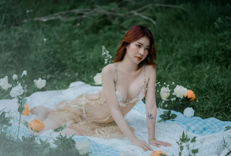 femme en nuisette transparente assise dans herbe