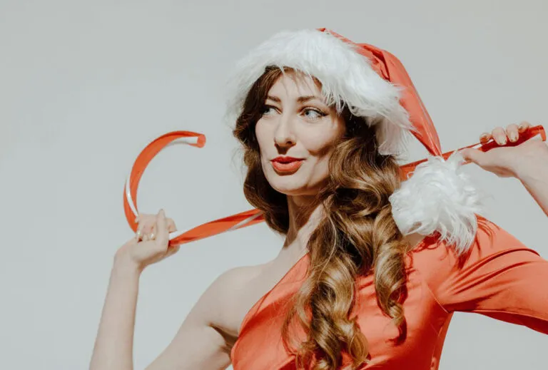 femme en robe rouge avec bonnet mère Noël et sucre d'orge