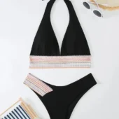 Vue de côté du bikini noir, soulignant la coupe échancrée et les bandes graphiques.