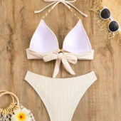 bikini-blanc-texture-dos Bikini blanc texturé côtelé, vue de dos montrant les bretelles nouées et les chaînettes dorées.