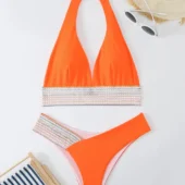 Vue de côté du bikini orange, soulignant la coupe échancrée et les bandes graphiques.