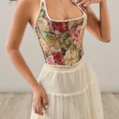 Zoom sur le motif floral tapisserie du corset, avec ses tons harmonieux de rose, vert et beige.
