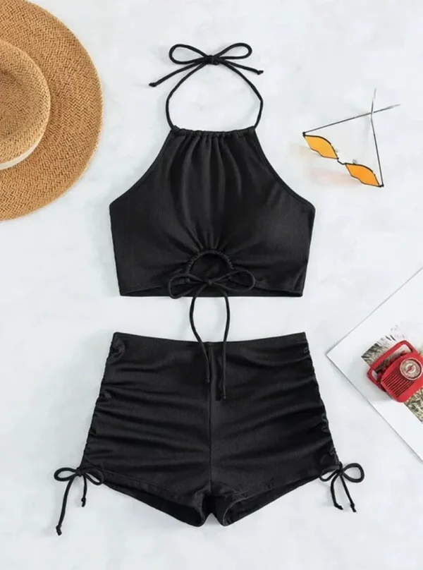Ensemble de bain deux pièces en noir, vue de devant montrant le top dos-nu ajustable et le shorty taille haute froncé.