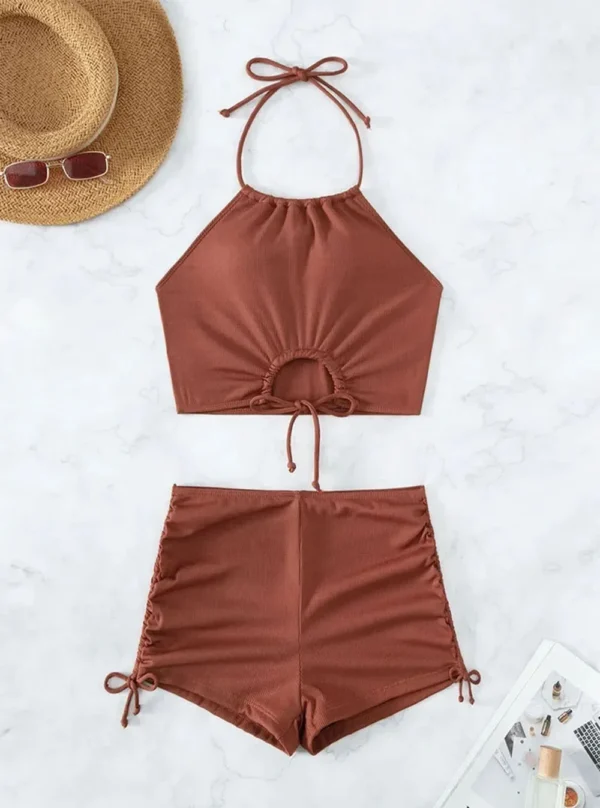 Détail des fronces latérales ajustables sur le shorty taille haute de l'ensemble de bain deux pièces, offrant une coupe modulable