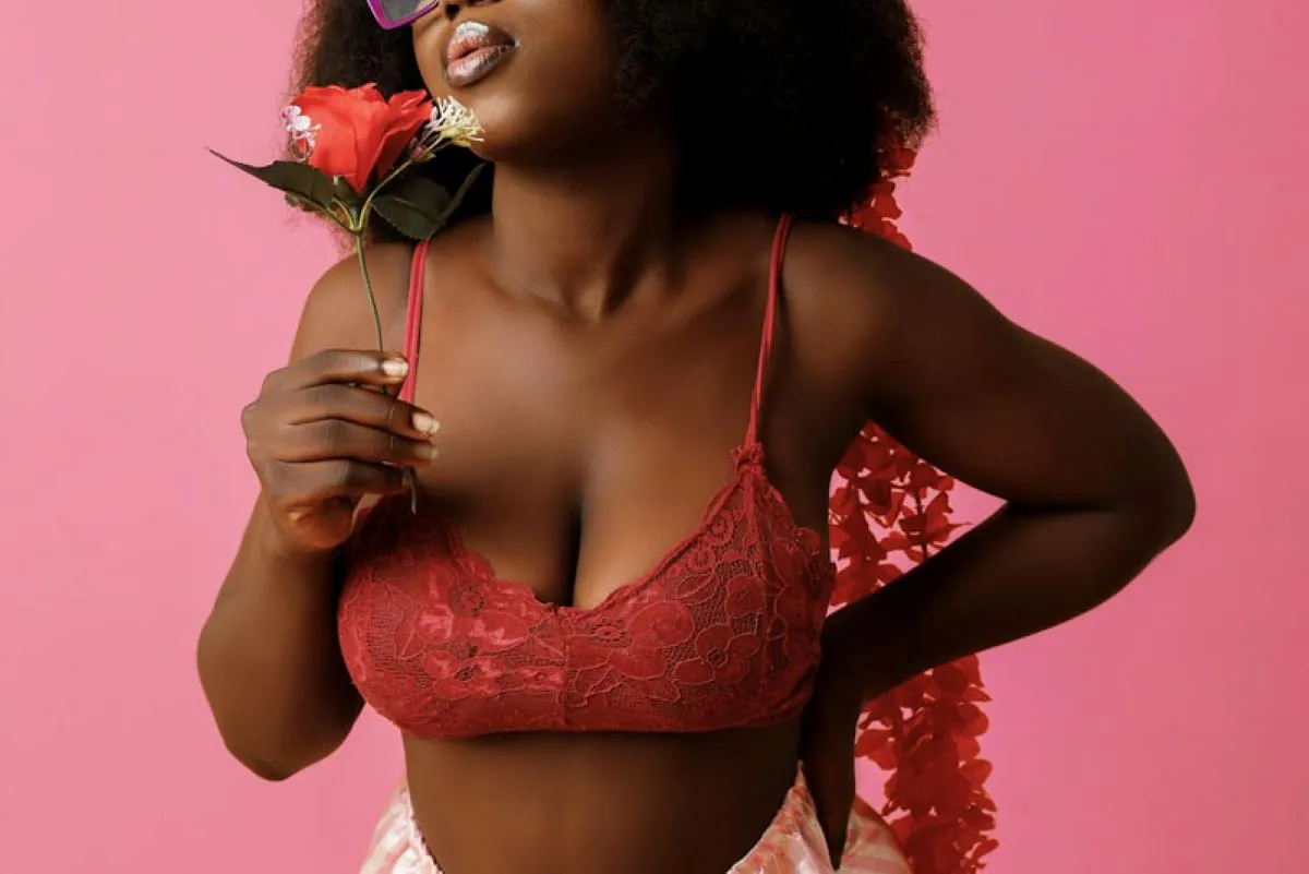 Femme portant une bralette rouge en dentelle, parfaite pour sublimer une poitrine généreuse.