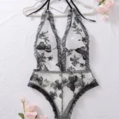 Body transparent dos nu avec broderies noires présenté à plat, détails visibles du tulle et des motifs floraux.
