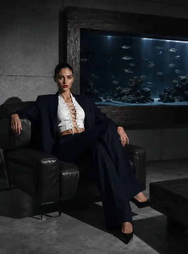 Haut cuir lacé Bianca blanc, pose assise sur fauteuil cuir noir, aquarium en arrière-plan