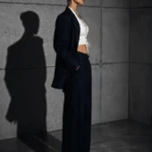 Haut cuir lacé Bianca blanc, vue de profil, ombre portée béton et pantalon large marine