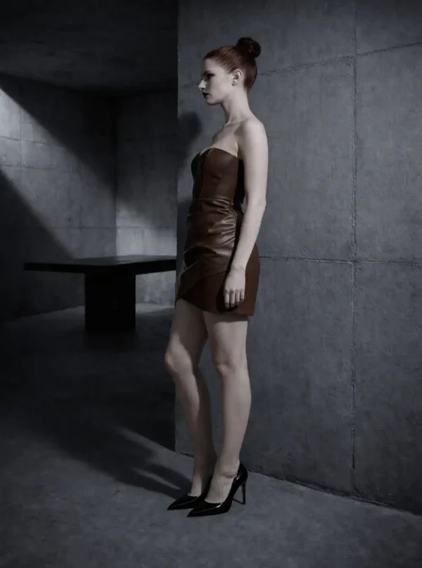 Robe bustier en cuir Aspa marron, vue de profil, taille marquée et décor béton